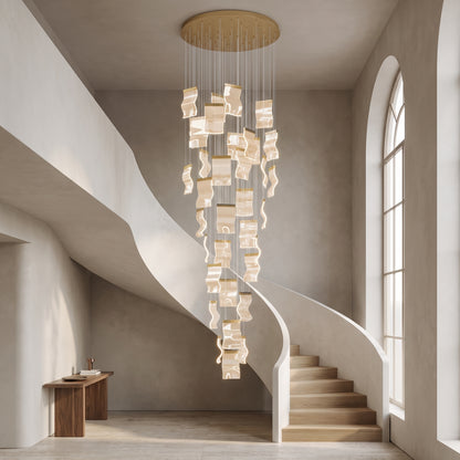 Nyra cascading chandelier in metallic gold in a double-height stairwell