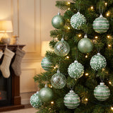 sage green ornaments hanging in a Christmas tree