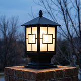 Oakmont post light glowing through framed frosted glass at November dusk