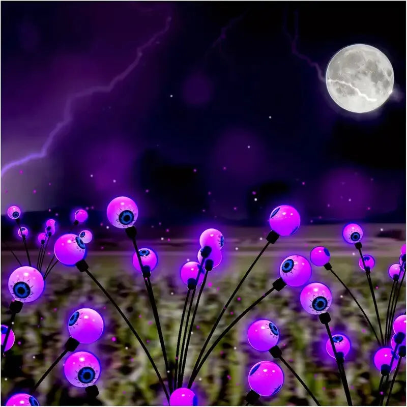 Solar Halloween eyeball lights glowing in a garden at night