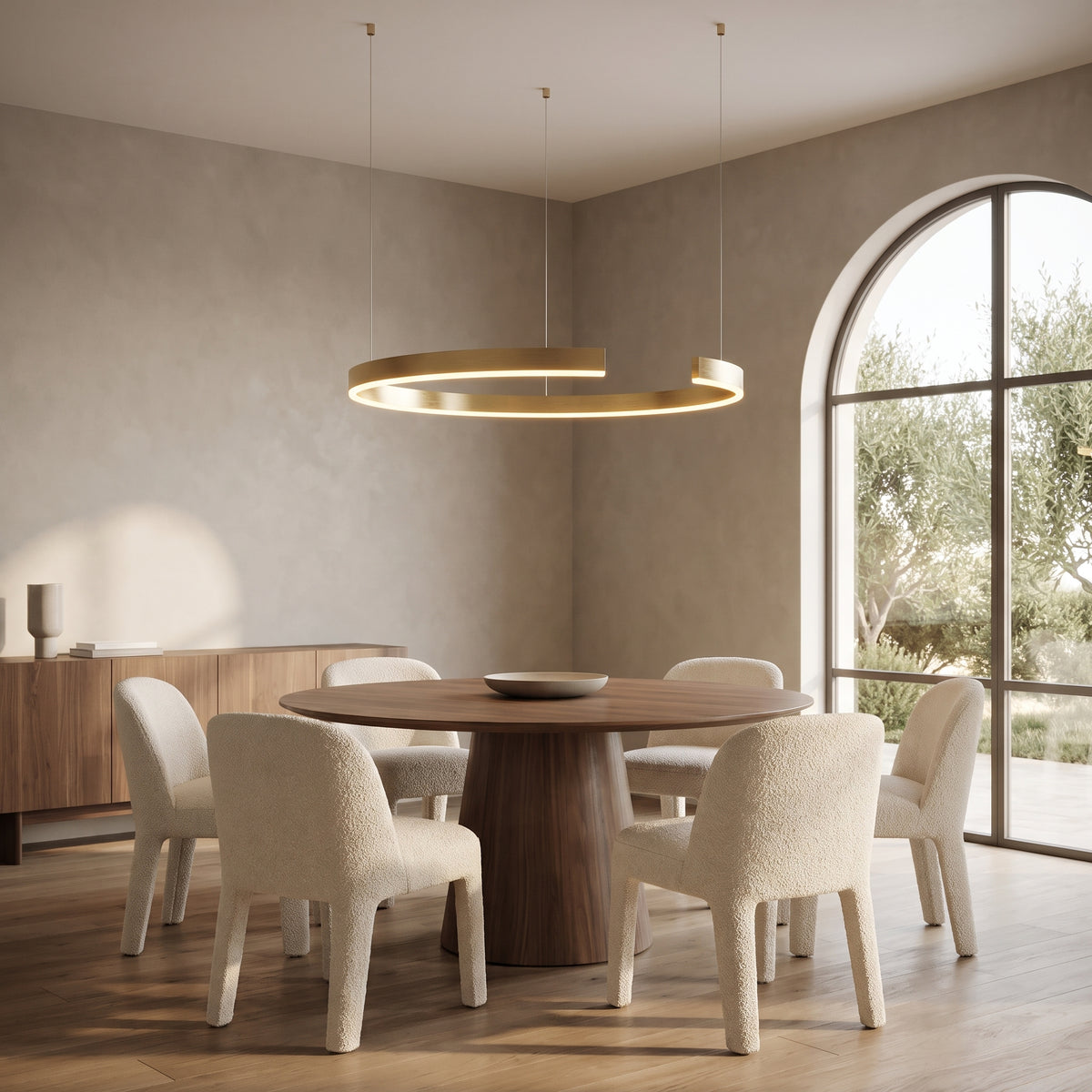 Gold-plated open ring chandelier hanging above a round walnut dining table