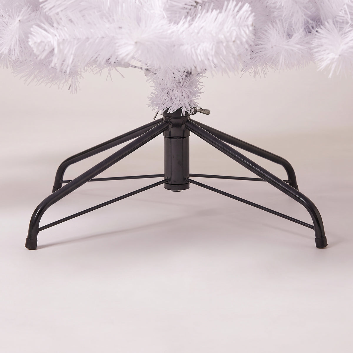 Close-up of the black folding metal tree stand of the white tree