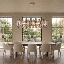 Seren smoky grey crystal chandelier above a long walnut dining table