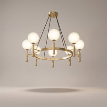 Solenne brass chandelier on a warm light grey studio background