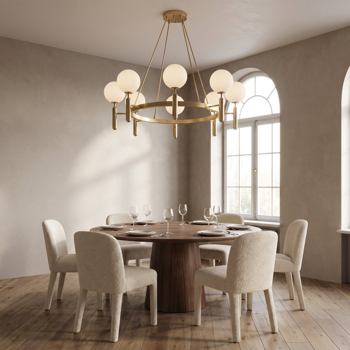 Solenne brass chandelier, round base, above a round walnut dining table