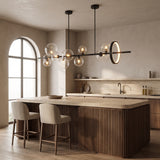 Wren black linear glass globe chandelier with gold ring above a walnut kitchen island